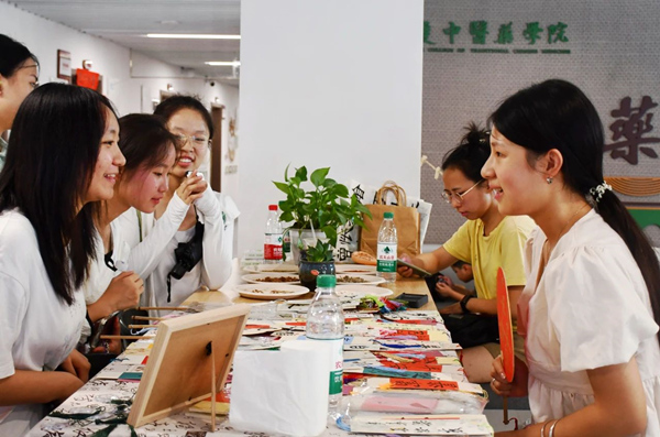 中药学院迎新现场，新生和家长们对各种中草药文创产品兴趣浓厚。taptap点点官方网站供图